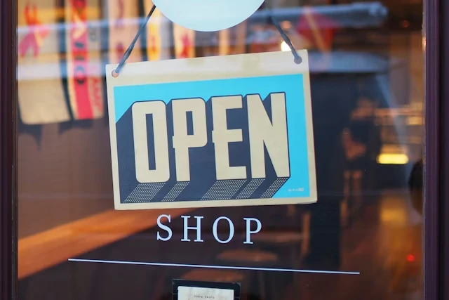 Open shop sign hanging in a retail storefront window